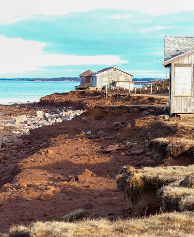 Weathered cottages perch on the edge of a ragged shoreline in Prince Edward Island that was badly eroded by Hurricane Fiona.