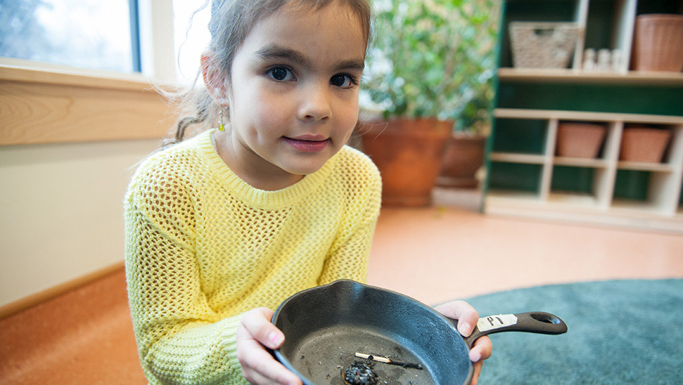 A child holding the smudge pan.