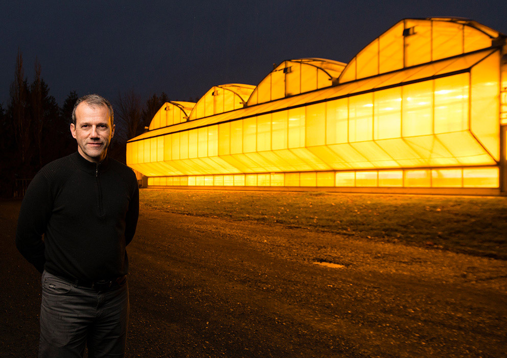 Professor Jean Caron posing in front of a greenhouse.