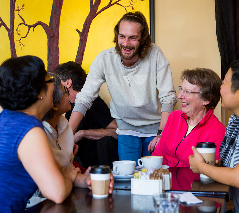 Un groupe de femmes conversant avec le copropriétaire du Caffé Cittadella.