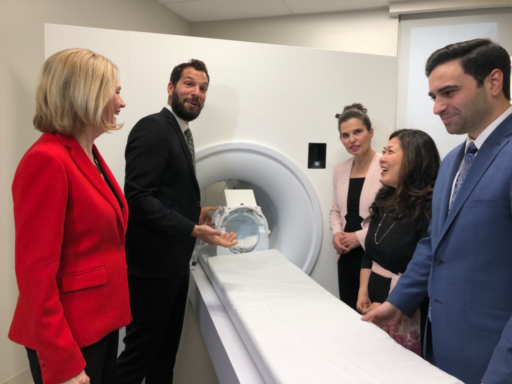 Various people in front of an MRI scanner.
