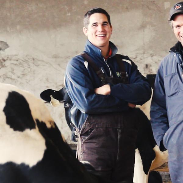 Les producteurs laitiers de la Saskatchewan Albert et Logan Leyenhorst, père et fils, en compagnie de leur troupeau dans l’étable.