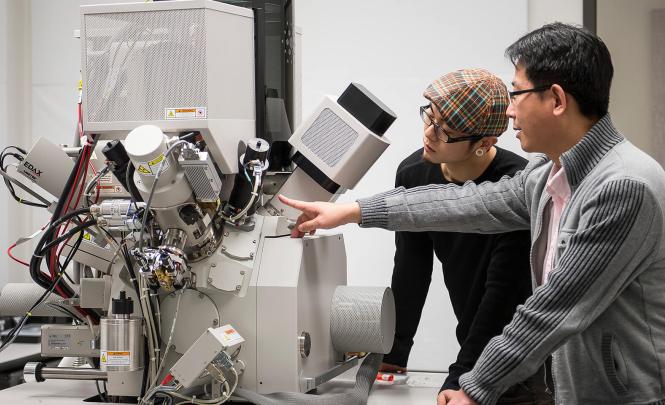 Two researchers operating research equipment.