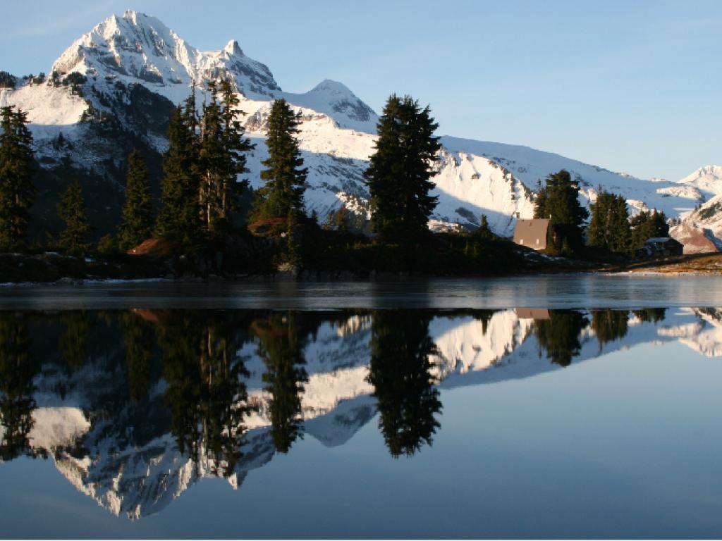 Montagnes enneigées avec un lac à l’avant-plan